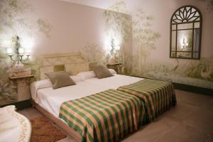 a bedroom with a large bed with a striped blanket at Casa de Solís in Trujillo