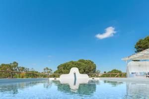 a pool at a resort with a blue sky at Monte da Torre in Melides