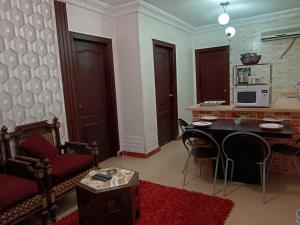 a living room with a table and chairs and a microwave at Bonne Vie Hotel in 6th Of October