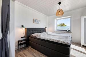 a bedroom with a bed and a window at Ferienhaus Deich Auf in Wesselburenerkoog