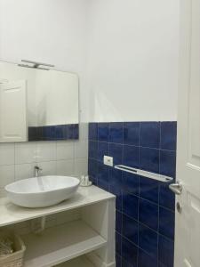 een badkamer met een witte wastafel en een spiegel bij Abagnale Home Sorrento in Sorrento
