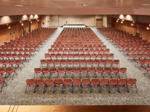 an empty lecture hall with red chairs and a podium at Novotel Athens in Athens +183 photos