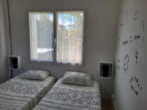 ein Schlafzimmer mit zwei Einzelbetten und einem Fenster in der Unterkunft Perfect Studio - au calme avec terrasse, jardin, piscine in Libourne + 26 Fotos