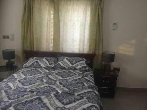 une chambre avec un lit avec une couette dessus dans l'établissement Modern One-Bedroom Retreat in North Legon, Accra, à North Legon
