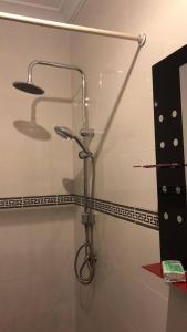 une douche dans une salle de bain avec une pomme de douche dans l'établissement Modern One-Bedroom Retreat in North Legon, Accra, à North Legon 18 autres photos