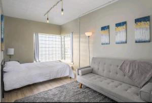 a bedroom with a bed and a couch at Downtown 2 Bedroom Apartment in Appleton