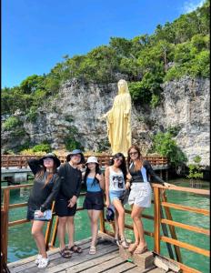 Un grupo de personas de pie en un puente frente a una estatua en Lucky one transient 3mins walk from whart, en Alaminos