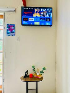 a television hanging on a wall with a table at The Qs guest suite in Brakpan
