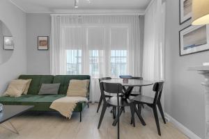 a living room with a green couch and a table at Castle Inn Apartments - Downtown Keflavík in Keflavík
