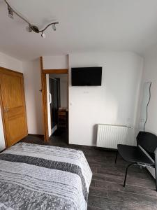 a bedroom with a bed and a television on the wall at Chambres D'hôtes Mongarny Cancale in Cancale