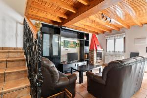 a living room with leather chairs and a table at Huerta El Pozu in Soto de las Dueñas