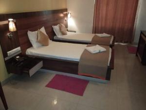 una habitación de hotel con dos camas y una mesa en Budget Hotel, en Khammam