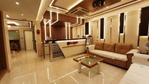 Una sala de estar con un sofá y una mesa de café. en Budget Hotel, en Khammam