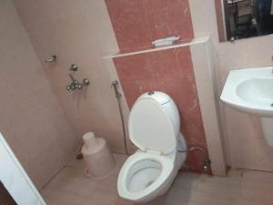un baño con inodoro y lavabo en Budget Hotel, en Khammam
