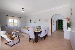 a living room with a table and chairs and a couch at J R Dream house in Quarteira