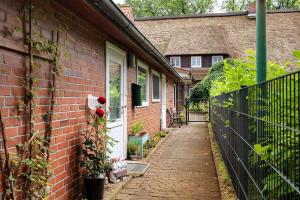 a brick house with a pathway leading to a door at Idyllisches Zimmer Im Grünen in Stelle