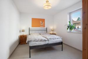 a bedroom with a bed and a window at Ferienwohnung am Klemmbach in Müllheim