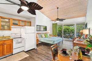 a kitchen and living room with a white refrigerator at Napili Shores D227 · NS D227 OceanFront Resort w Pool in Kahana