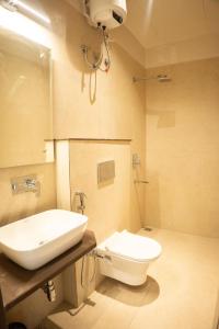 ein Badezimmer mit weißer Toilette und Waschbecken in der Unterkunft Jagrit a Boutique stay in Varanasi