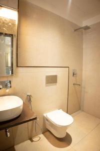 ein Badezimmer mit Toilette, Waschbecken und Dusche in der Unterkunft Jagrit a Boutique stay in Varanasi