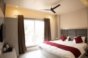 ein Schlafzimmer mit einem Bett mit einem großen Fenster in der Unterkunft Jagrit a Boutique stay in Varanasi