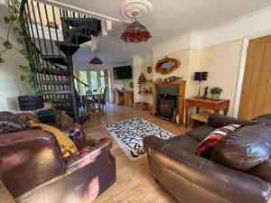 WoottonにあるSquirrel Havenのリビングルーム(革製家具付)、螺旋階段