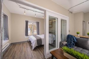 a bedroom with a bed and a couch and a window at Downtown 2 Bedroom Apartment - Free Parking in Appleton