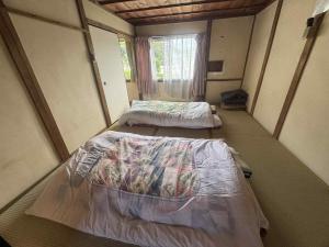 two beds in a small room with a window at くりのやかた Kuri no Yakata in Minami-ura