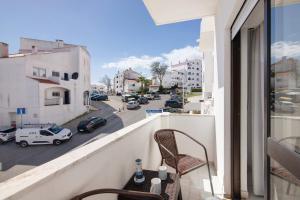 einen Balkon mit einem Stuhl und Straßenblick in der Unterkunft City Center Albufeira in Albufeira