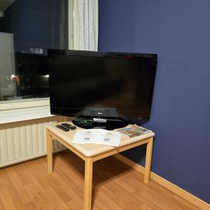 Ein kleiner Tisch mit einem Fernseher an einer blauen Wand in der Unterkunft Kodikas yksiö Heinolan keskustassa in Heinola + 4 Fotos