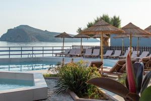 アギア・マリーナ・ネア・キドニアスにあるHotel Haris on the beachの海のそばのプール(椅子、パラソル付)