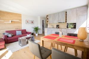 a living room with a table and a red couch at Ferienwohnungen Vogelsang in Saalhausen