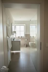 a white bathroom with a sink and a toilet at Ferienwohnungen Vogelsang in Saalhausen +32 photos