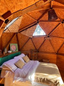 Cama en habitación de madera con techo en DomosdeMar a 100 mts del mar, en Ocean Park