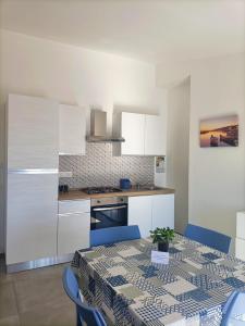 a kitchen with a table with blue chairs around it at La Perla del Mare in Pisciotta