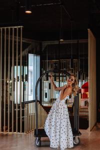 une femme en robe à pois debout près d'un portail dans l'établissement Radisson RED Galway, à Galway