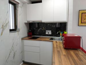 a kitchen with white cabinets and a red appliance at Ametlla Mar Benidorm in Benidorm