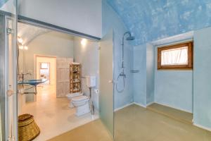 a bathroom with a toilet and a glass shower stall at Masseria Scafazzi - Salento in Presicce +146 photos
