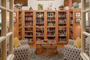 a library with wooden book shelves filled with books at Dancing Moon Luxury Loft and Event Space - Sleeps 12 in Oshkosh