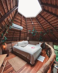 a bedroom with a bed in a thatched room at Satori Zen Club in Itauguá +73 photos