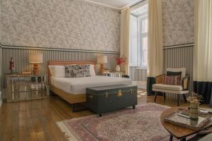 a bedroom with a bed and a chair at Sapateiros 44 in Lisbon