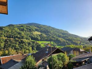 a village with a mountain in the background at Logis Les Forges in Arvillard