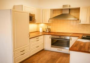 Una cocina con gabinetes blancos y una estufa. en Prázdninový dům - Bechyně, en Bechyně