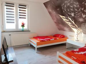 a bedroom with two beds and a wall with a mural at Fewo zum Huberts Schweinchen in Frankenhain