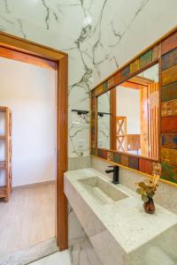 a bathroom with a sink and a mirror at Village das Estações in Marau