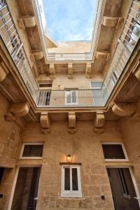 a tall building with a ceiling with a window at Old Lodge Apartment 6 by Vallettastay in Valletta +2 photos