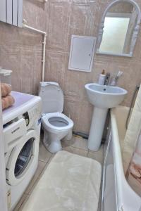 ein Badezimmer mit Waschmaschine und Waschbecken in der Unterkunft Однокомнатная на Хиуаз Доспановой 73 in Oral
