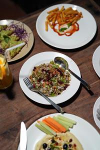 four plates of food on a wooden table at Hotel Casa De Patio in Porvorim