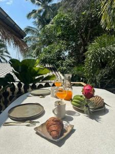 a table with a plate of food and fruit on it at Happy Coco Monkey - Cozy Studio By Sp Villa in Koh Phangan