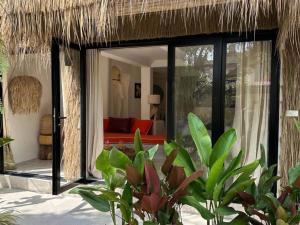 a villa with a thatch roof and a living room at Happy Coco Monkey - Cozy Studio by SP Villa in Ko Phangan